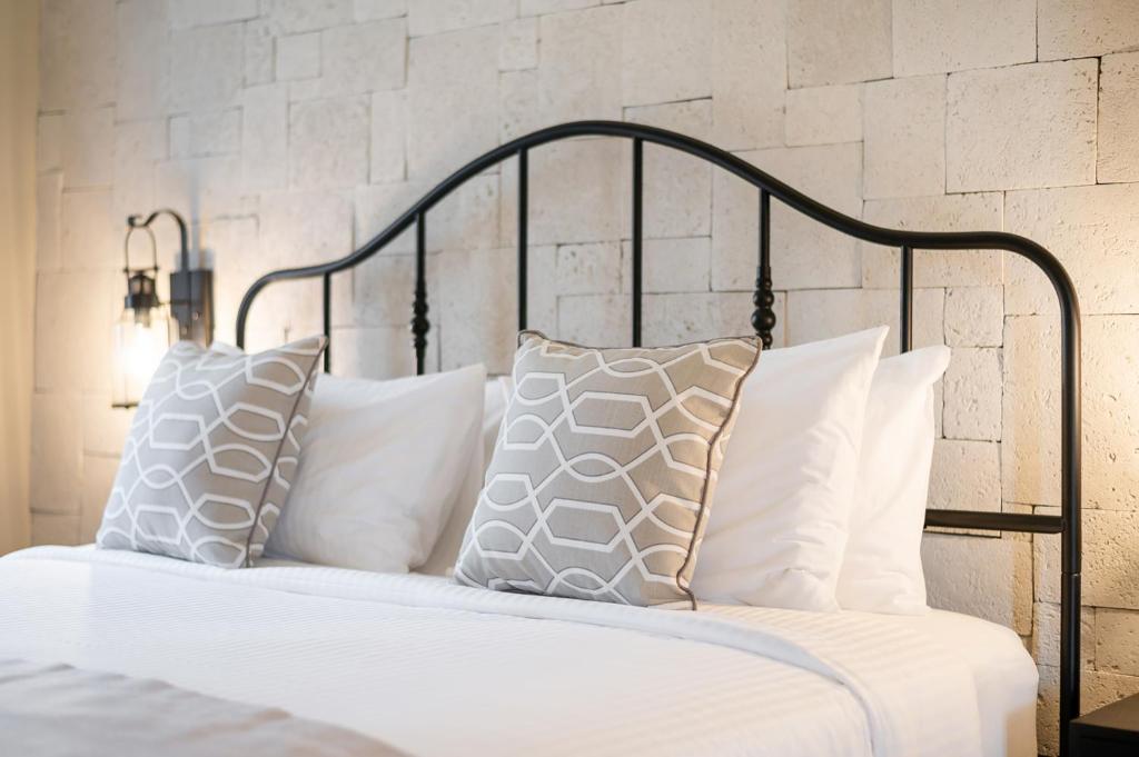 - un lit avec des oreillers blancs et une tête de lit noire dans l'établissement Locanda Villanova Bed & Breakfast, à Pak Chong