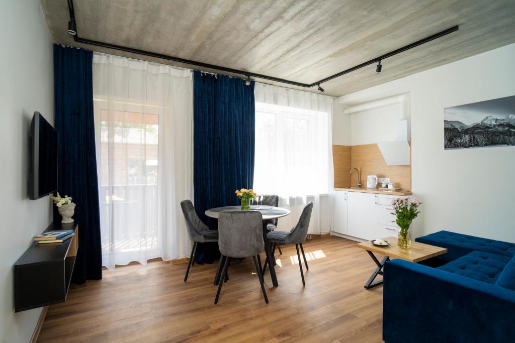 uma sala de estar com uma mesa e um sofá azul em Fort63 apartments em Kaunas