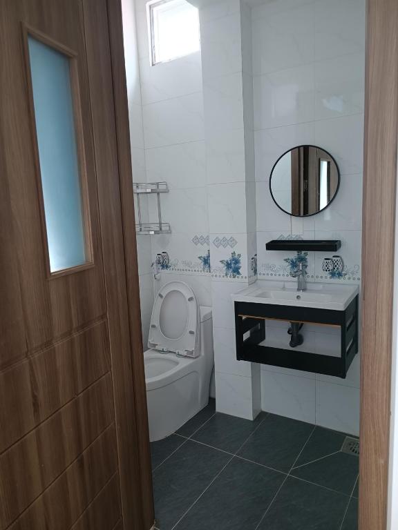 芹苴的住宿－Kim Ngân 2's，一间带卫生间、水槽和镜子的浴室