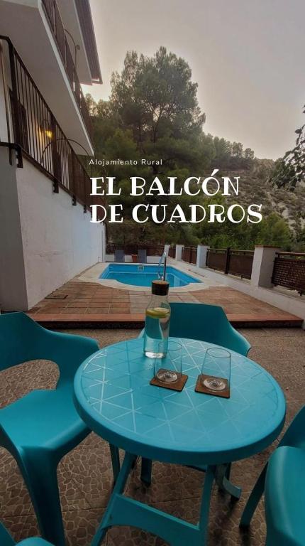 einem blauen Tisch mit zwei Stühlen und einem Glas in der Unterkunft El balcón de Cuadros in Bedmar