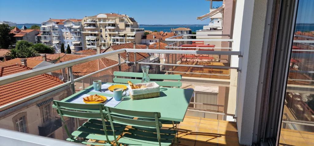 balcón con mesa, sillas y vistas en Appartement avec 5 balcons et parking au cœur de la ville!, en Arcachon