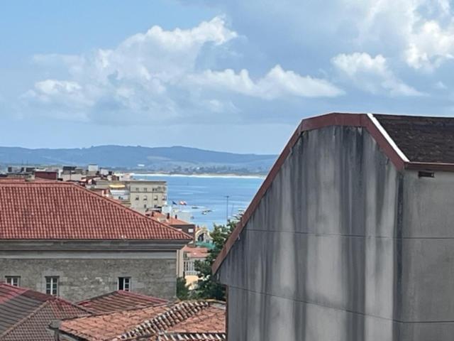 Blick auf das Meer von einer Stadt mit Dächern in der Unterkunft Apartamento Moises in Santander