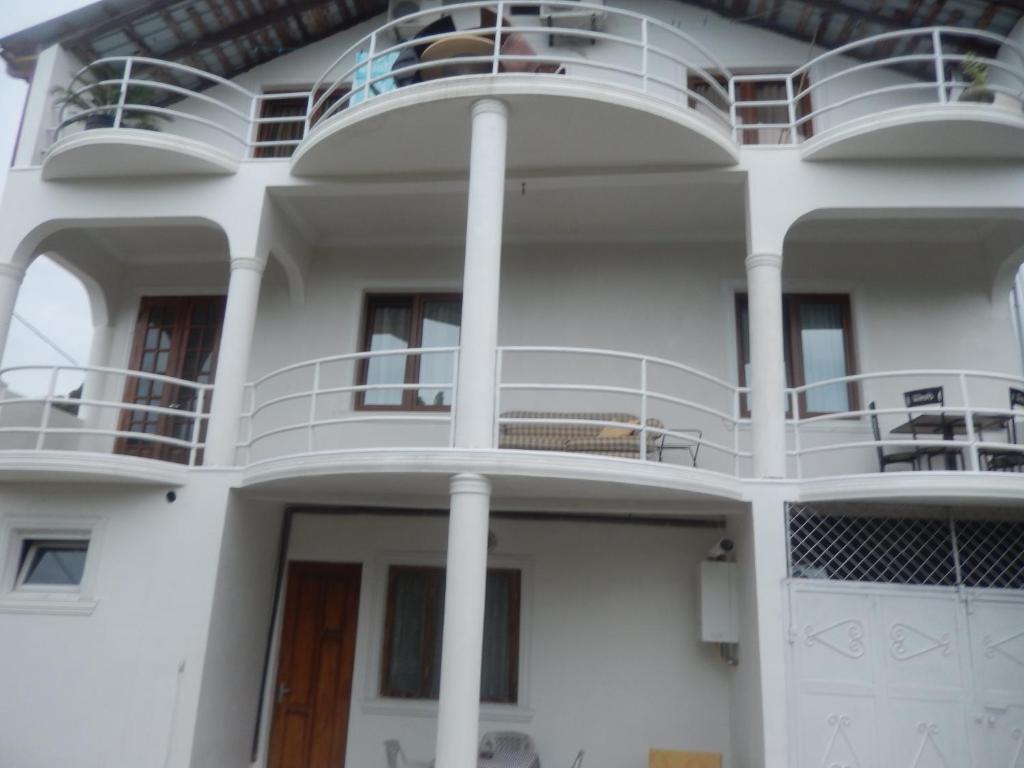 a white house with a balcony on a cruise ship at Merabi Guest House in Makhinjauri