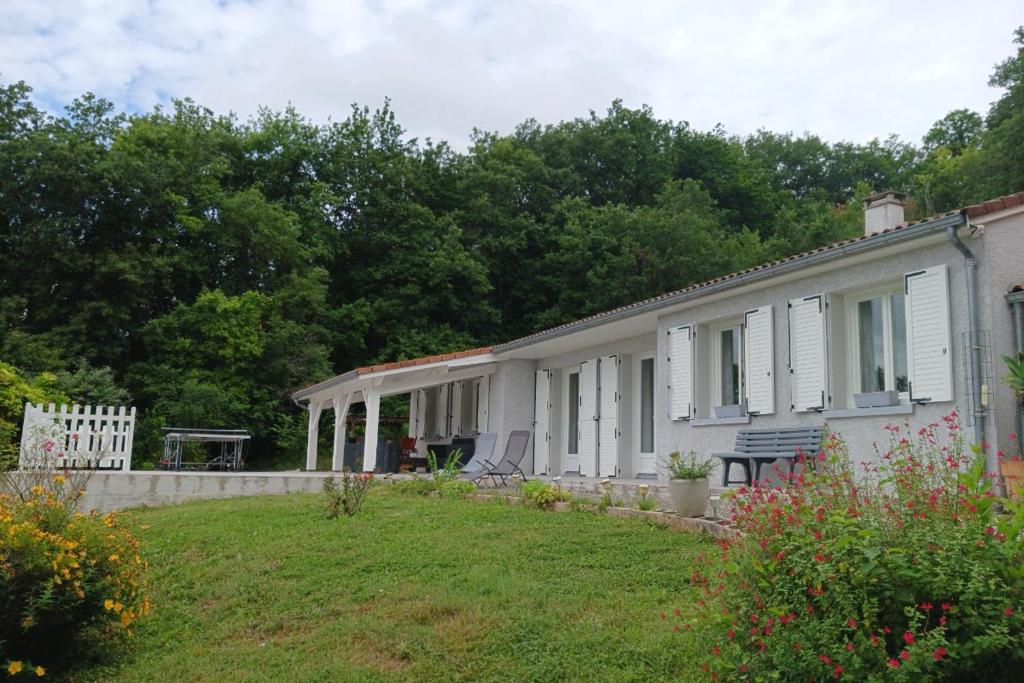 una casa blanca con un patio delante en Au bois dormant, en Pont-du-Casse