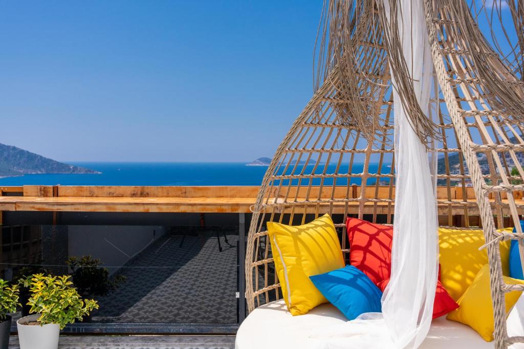 a hanging hammock with colorful pillows on a balcony at Lupia Suites in Kalkan