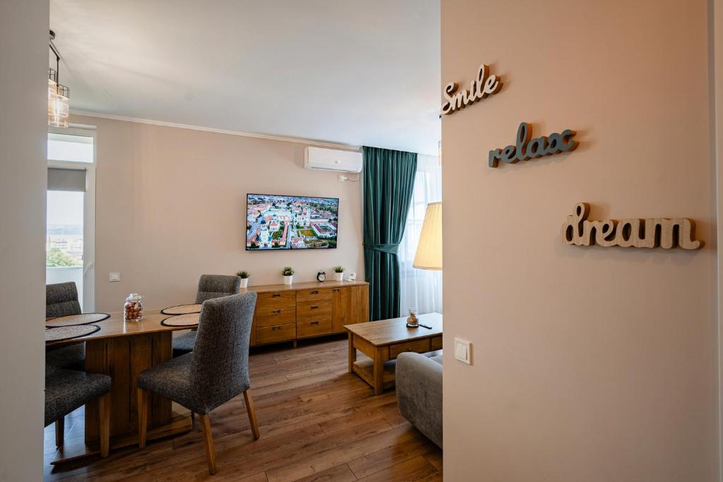 a living room with a table and chairs and a tv at Apartamentul Cetății Alba Iulia in Alba Iulia