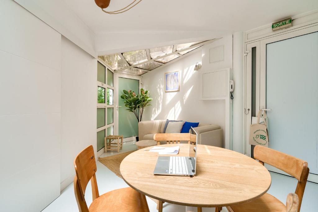 - une salle à manger avec une table et un ordinateur portable dans l'établissement Nocnoc Le Parasol, à Marseille