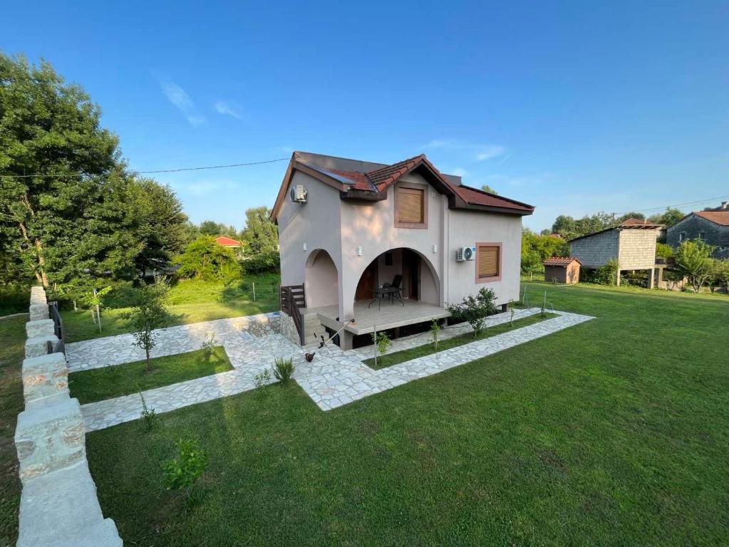 uma pequena casa num campo de relva verde em Zabljak Crnojevica ( National Park Skadar Lake) em Žabljak