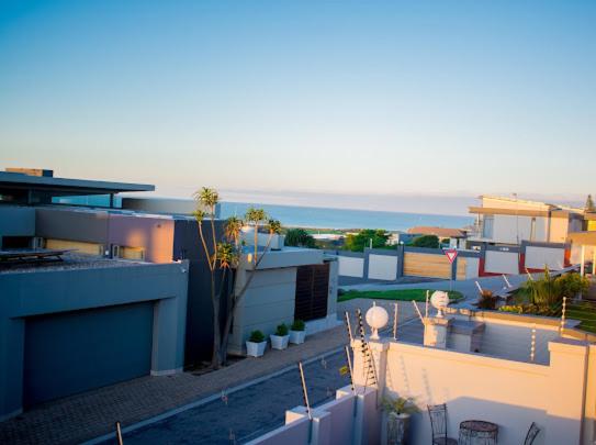 a view of a building with the ocean in the background at Sapphire Seas Beach Apartment in Humewood