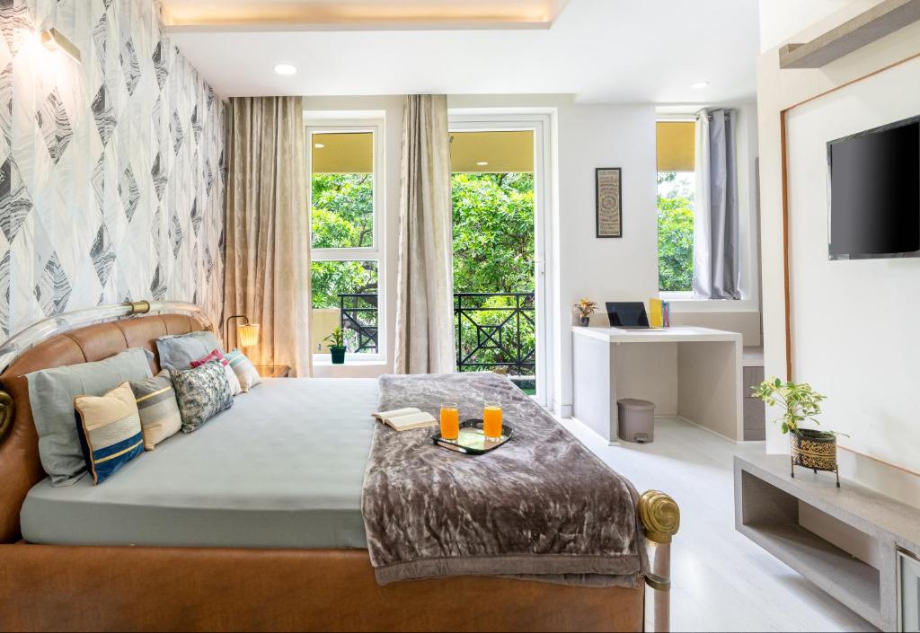 uma sala de estar com uma cama e uma televisão em Homlee-3bhk Green Luxury in SDEL em Nova Deli