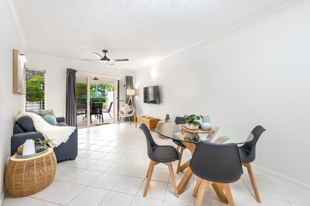 Cairns Esplanade 2BR Waterfront Apartment Sleeps 6 في كيرنز: غرفة معيشة مع طاولة وكراسي