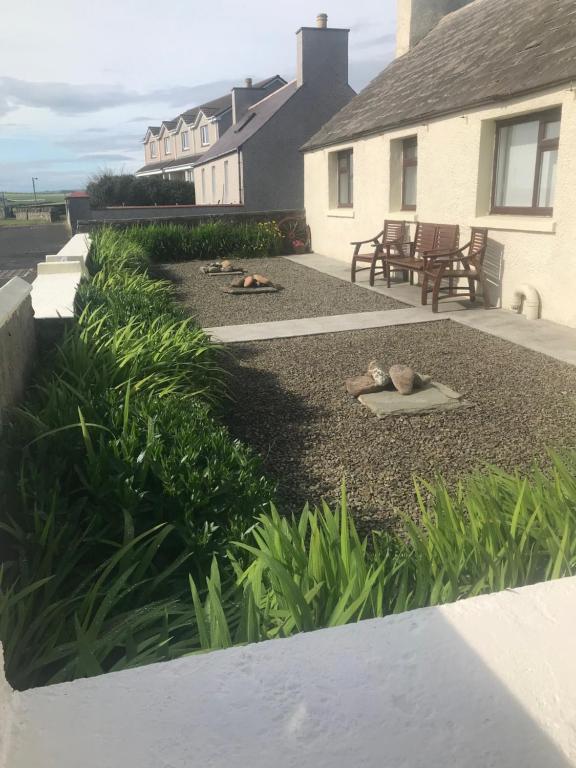 a yard with a patio with a bench and plants at Park Cottage in Saint Marys