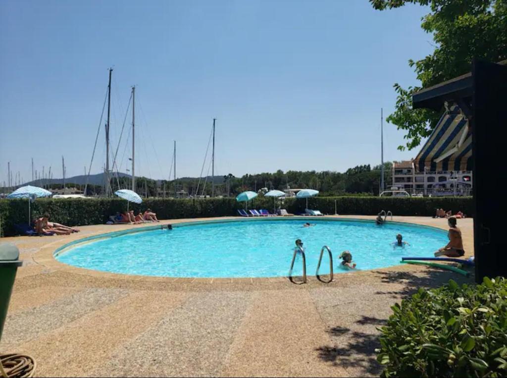 une grande piscine avec 2 personnes dans l'eau dans l'établissement L'Atelier Marin sur le Port des Marines, à Cogolin