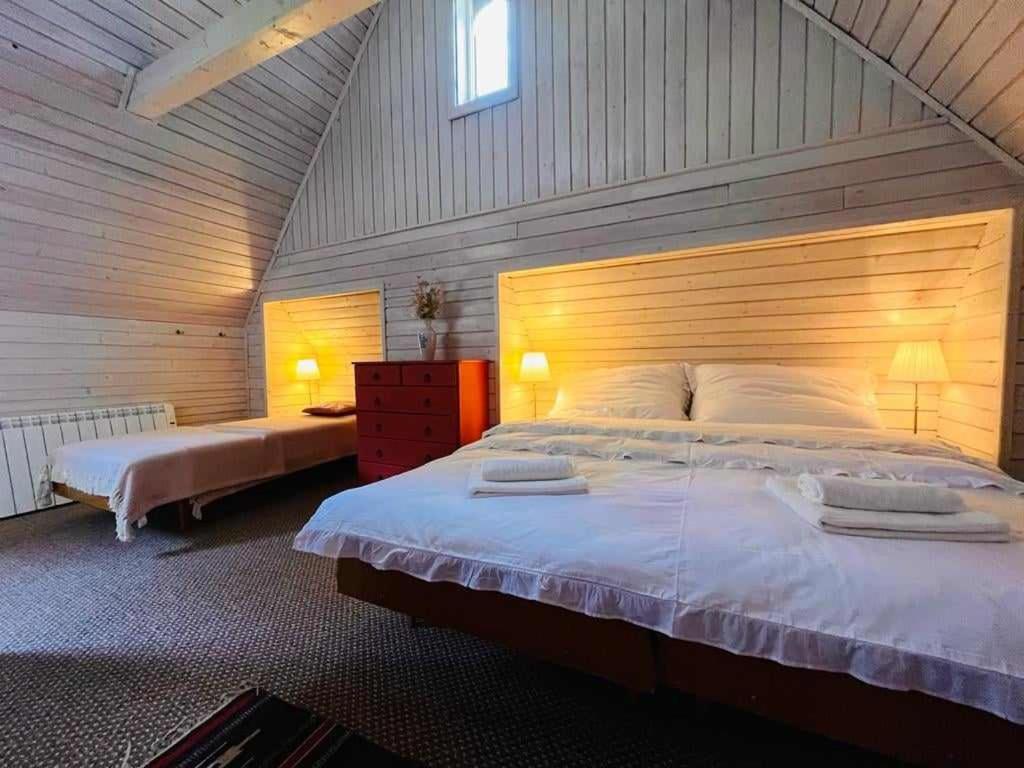 a bedroom with a large bed with a wooden headboard at Cesta z mesta na Huty in Huty