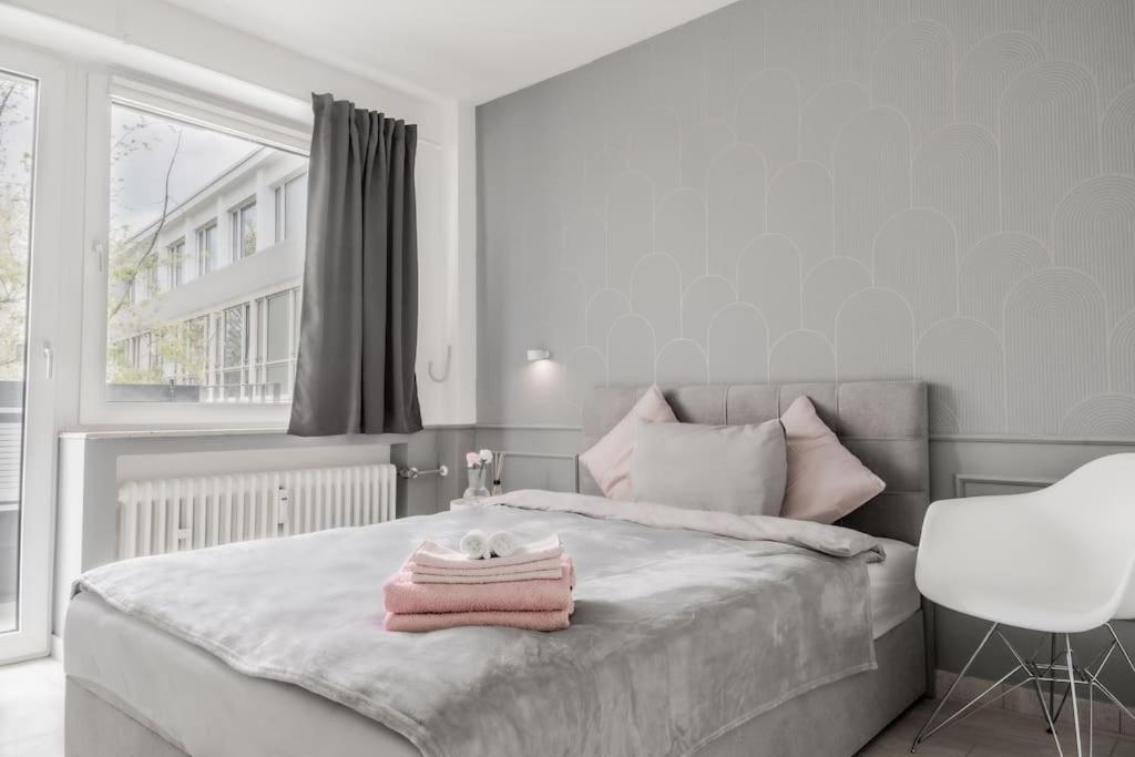 Un dormitorio con una cama con toallas rosas. en Cozy Apartment in Prime Location with Balcony - Hotel Comfort in 2 Room Apartment in Cologne Neumarkt - City Loft 11 - en Colonia