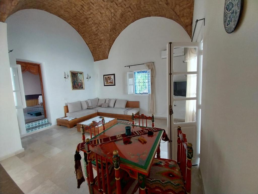 een woonkamer met een tafel en een bank bij Tamalou Djerba in Midoun