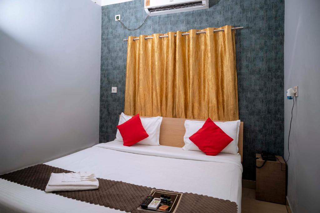 1 cama con almohadas rojas y blancas en una habitación en Hotel Town and country inn ( a unit of GS RESIDENCY) en Guwahati
