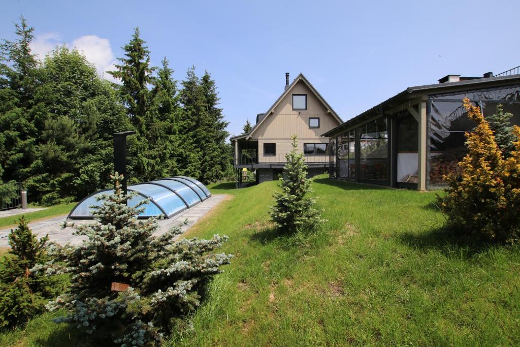 ein Haus mit einem Garten mit Bäumen und einem Gebäude in der Unterkunft Chata Jestřábník in Dolní Morava