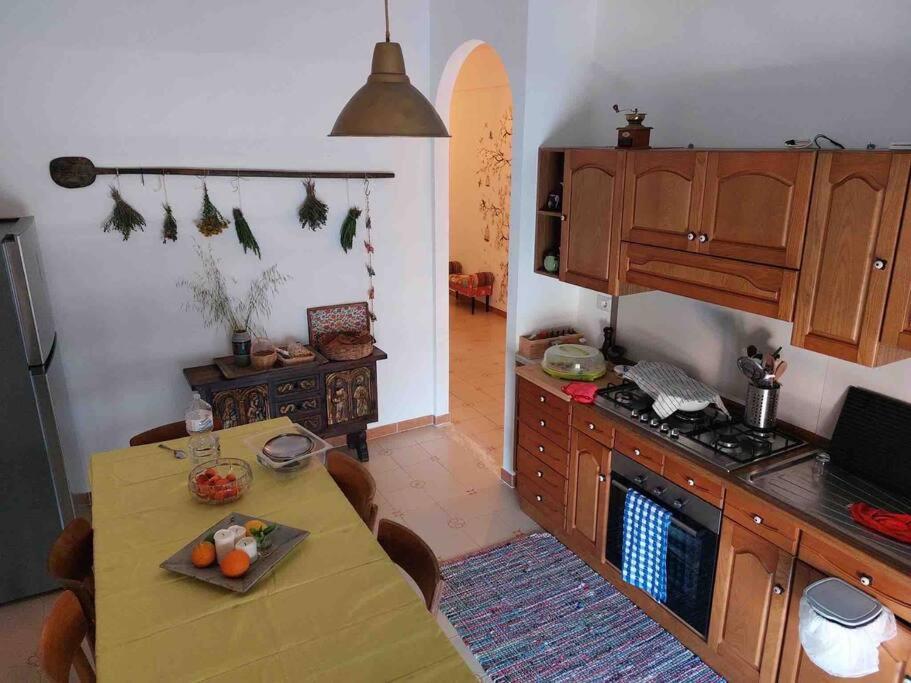 eine Küche mit einem Tisch und einem Herd Top-Backofen in der Unterkunft Casa via Mare in Rocca Imperiale