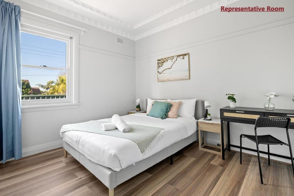 a white bedroom with a bed and a desk at Comfort Queen Room - Private - Prime Spot in Sydney