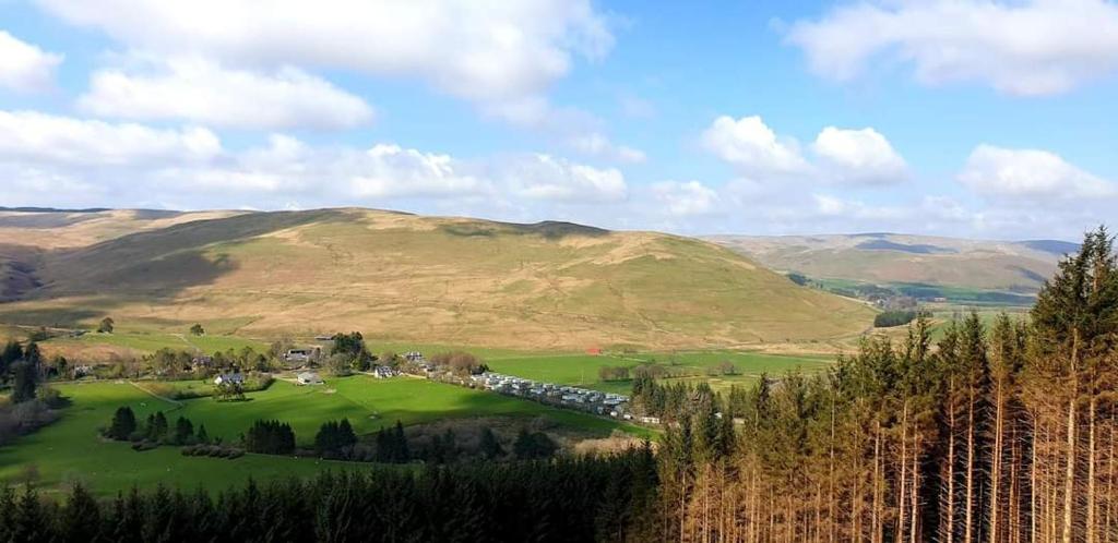 a view of a golf course in the hills at Honey Cottage Caravan Park in Selkirk