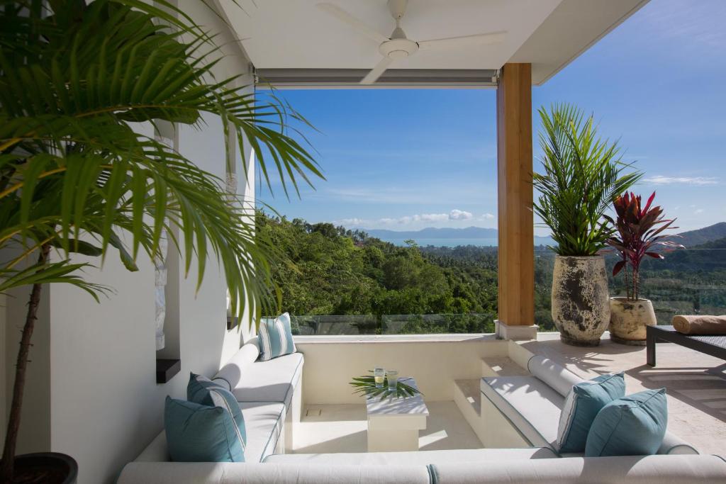 sala de estar con muebles blancos y ventana grande en Zog Villas, en Koh Samui 