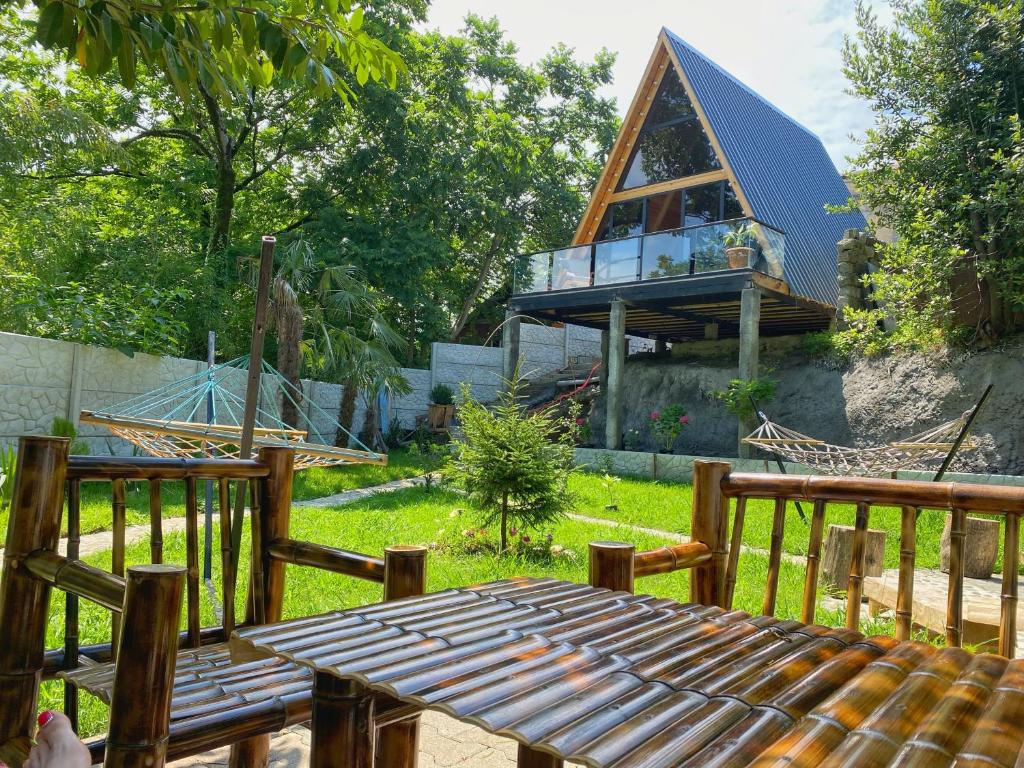 a wooden deck with a wooden table and a house at Sun House in Batumi