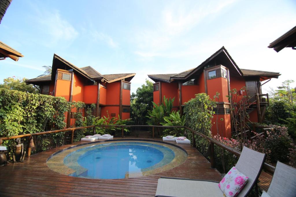 a house with a swimming pool in front of it at Pousada Triboju in Fernando de Noronha
