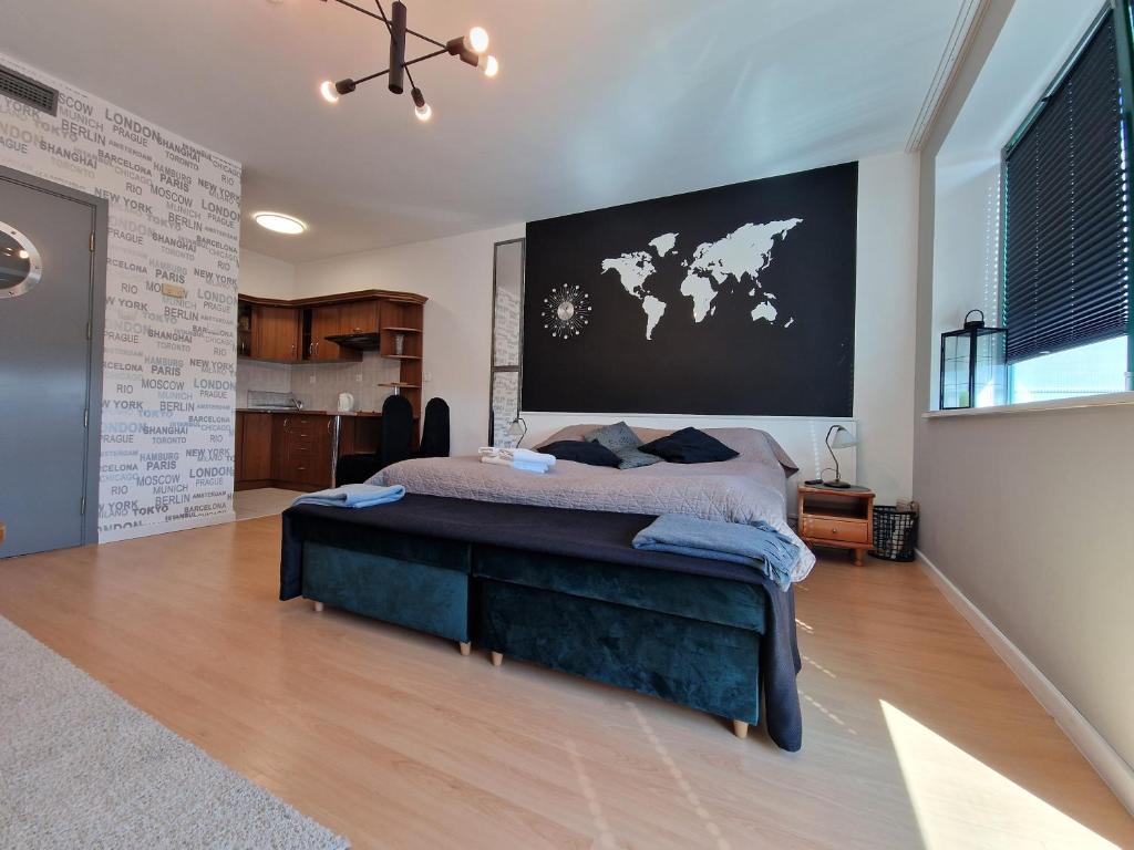 a bedroom with a large bed with a map on the wall at Apartament Słoneczny in Kołobrzeg