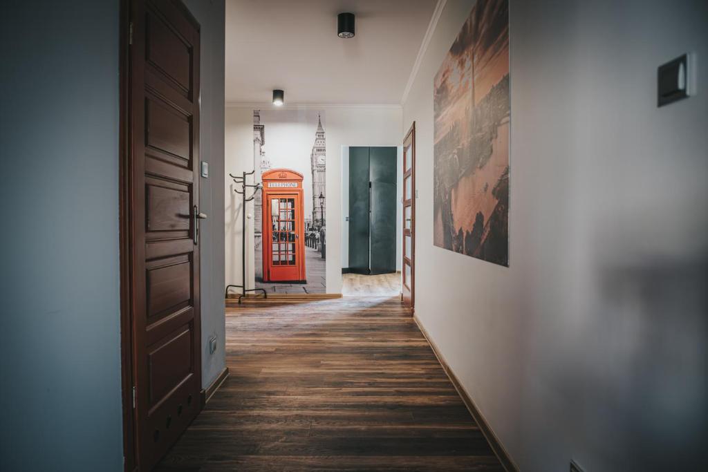 Un pasillo con una cabina telefónica roja a lo lejos en Apartament London, en Kielce