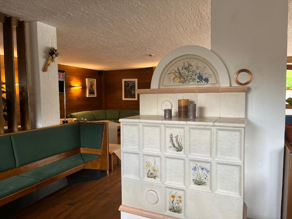 ein Wohnzimmer mit einer Bank und einem Regal mit Blumen darauf in der Unterkunft Hotel Alle Tre Baite in Santa Caterina Valfurva