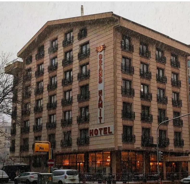 アンカラにあるGrand Hamit Hotelの雪の大通り沿いの大きな建物