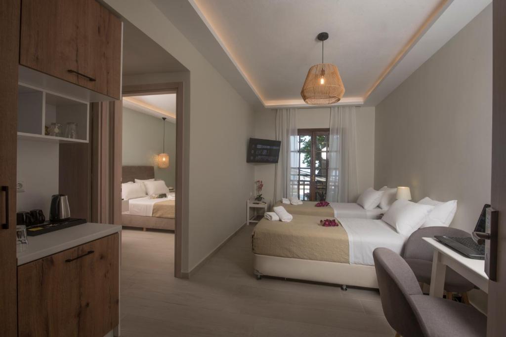 una camera d'albergo con due letti e una cucina e una camera di Hermes Hotel a Chorefto