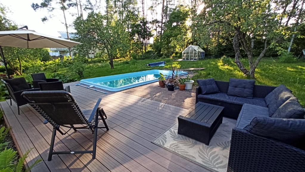 a patio with furniture and a swimming pool at Talo uima-altaalla in Hämeenlinna