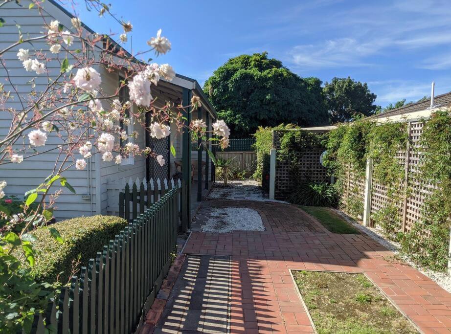 a fence with a brick walkway next to a house at Badger’s Inlet Devonport in Devonport