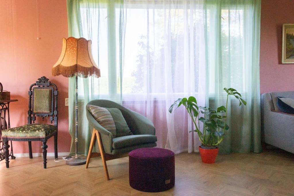a living room with a chair and a window at Norrby Residence,my vintage bnb 