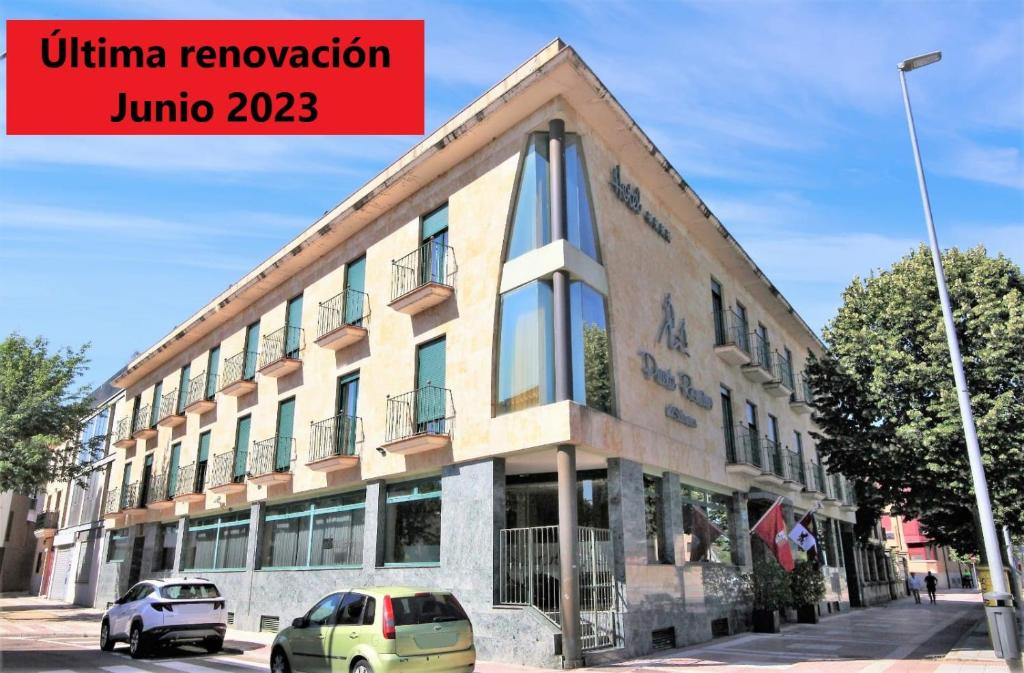 un edificio con coches estacionados frente a él en Hotel Ele Puente Romano de Salamanca en Salamanca