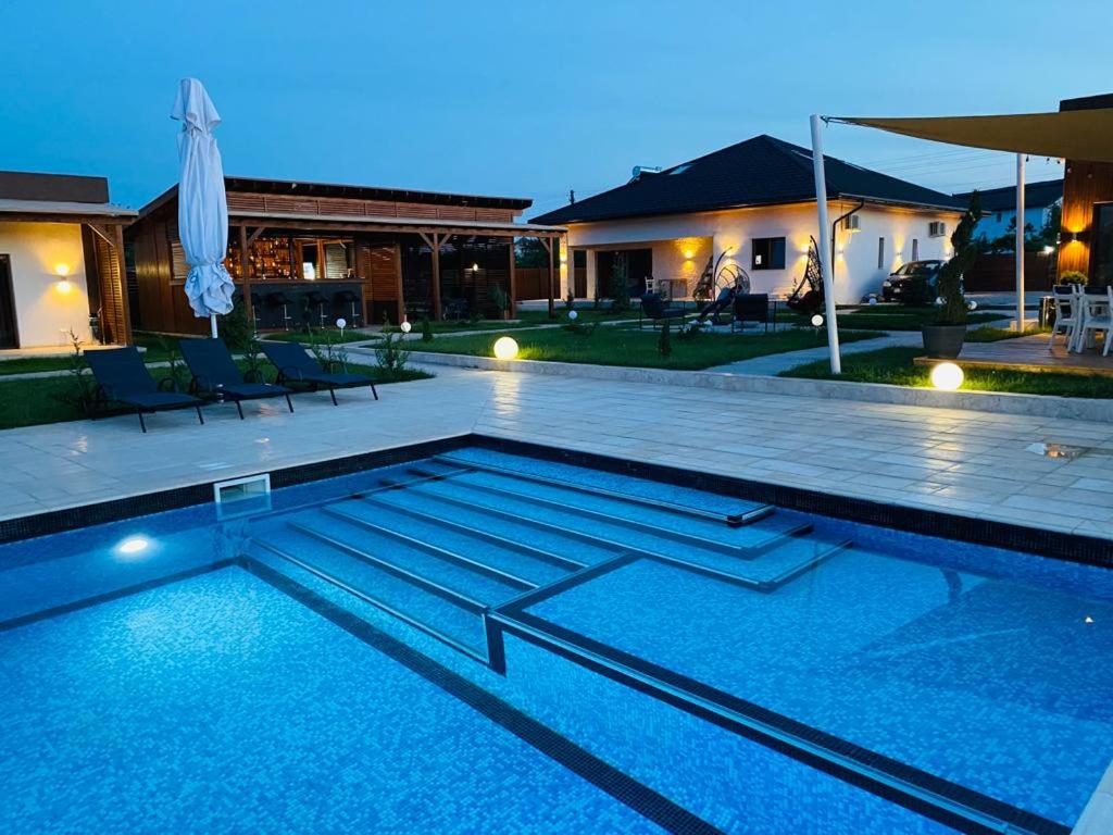 a swimming pool in front of a house at Havana Resort in Murighiol