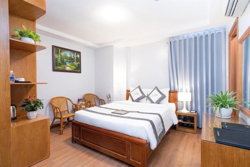 ホーチミン・シティにあるYen Nam Hotel Hoang Van Thuのベッドとテレビが備わるホテルルームです。