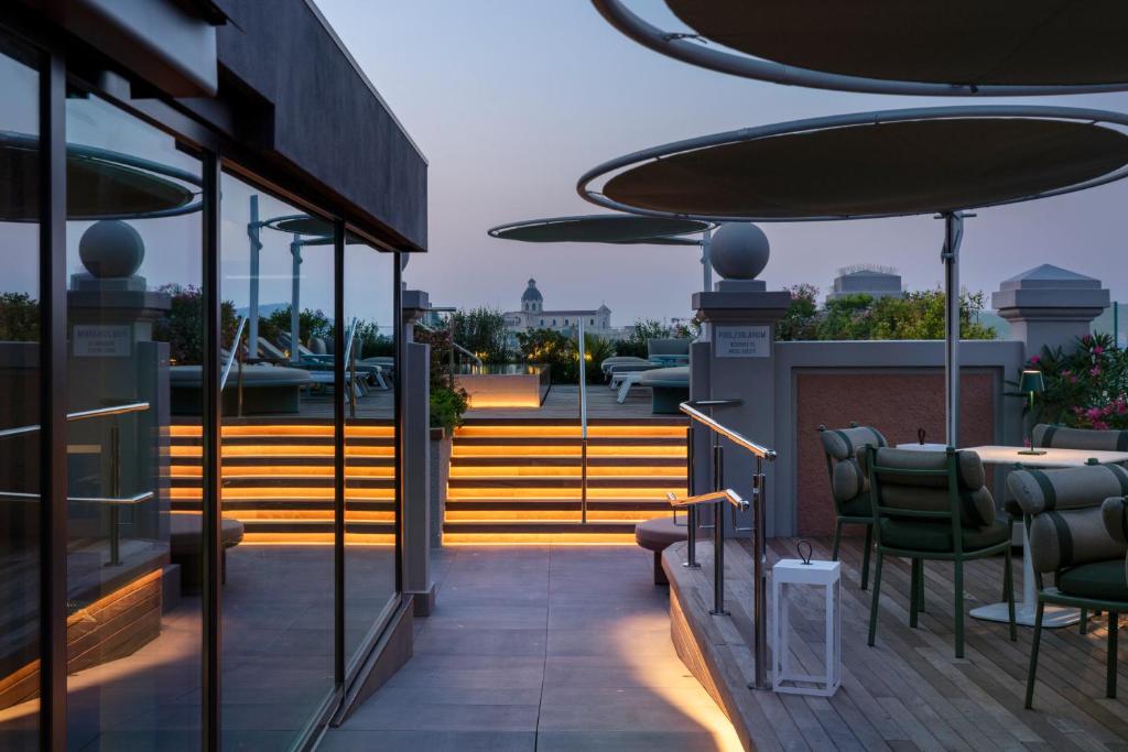 a balcony with chairs and a table on a building at Palazzo Tirso MGallery Cagliari in Cagliari