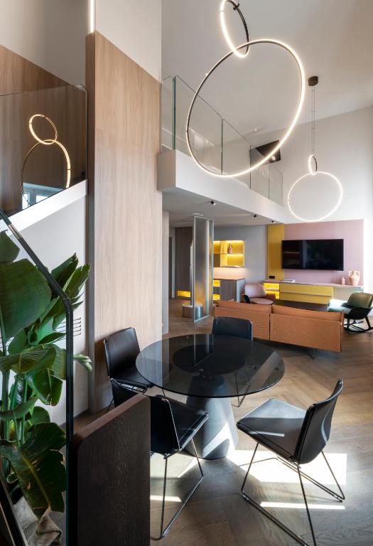 a dining room with a black table and chairs at Palazzo Tirso MGallery Cagliari in Cagliari