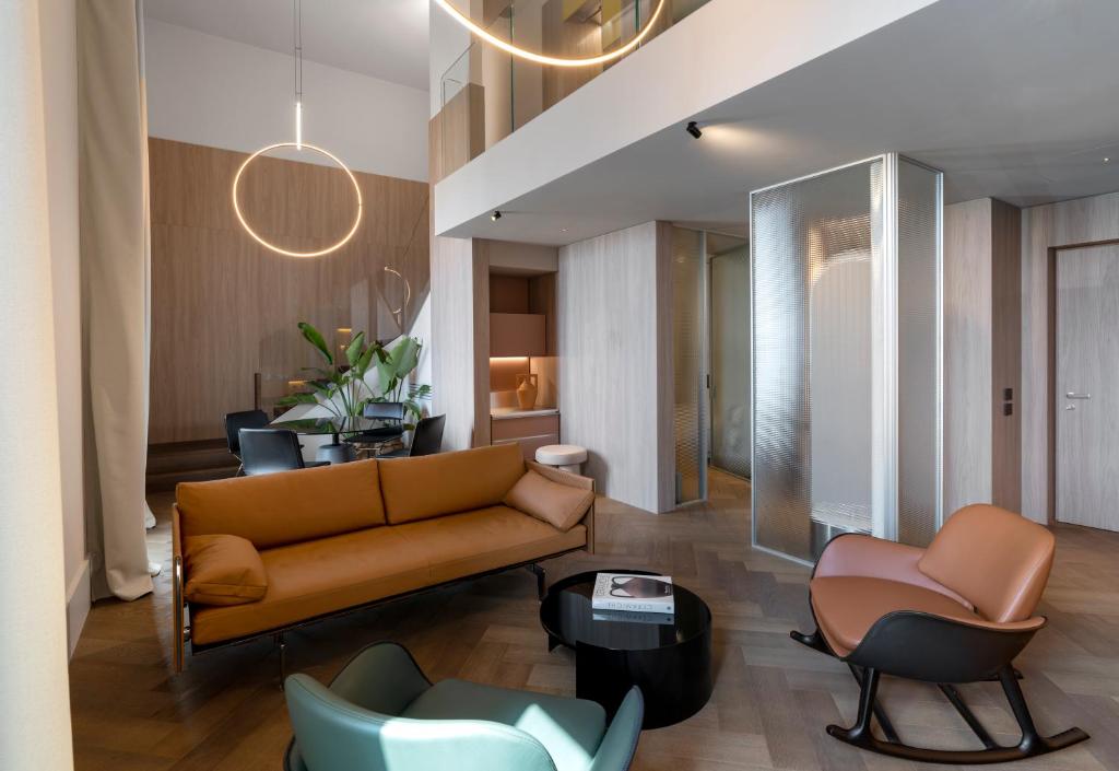 a living room with a couch and chairs at Palazzo Tirso MGallery Cagliari in Cagliari