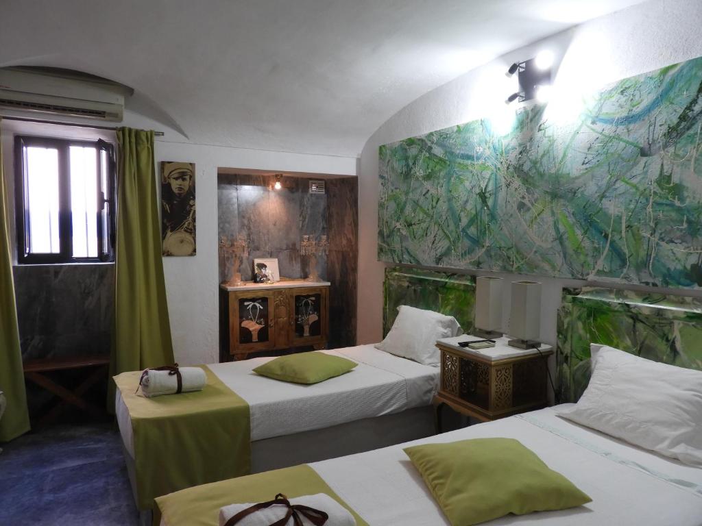 アランドロアルにあるAlandroal Guest House, Hotelのベッド2台付きの部屋、壁に地図を用意しています。