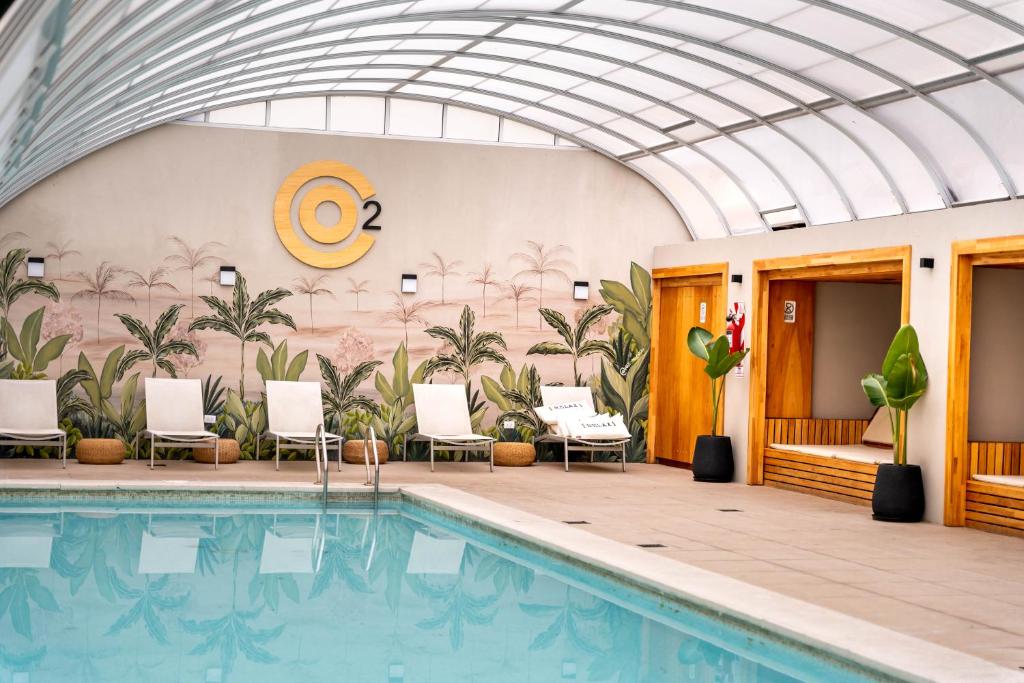 uma piscina num hotel com cadeiras e um tecto em O2 Hotel Mar del Plata em Mar del Plata