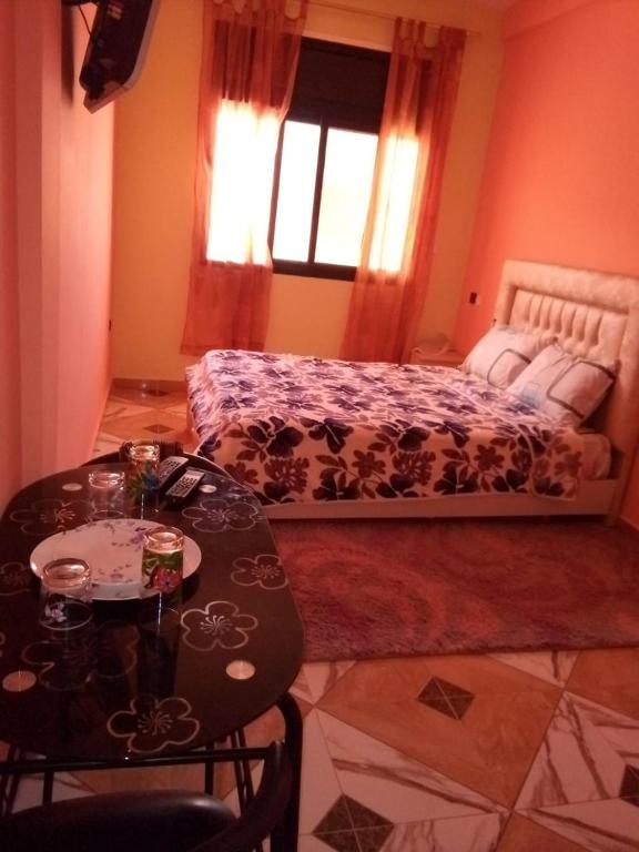 um quarto com uma cama, uma mesa e cadeiras em Blue Meadow em Moulay Bousselham