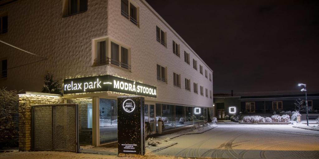un hôtel avec un panneau devant un bâtiment dans l'établissement Modrá Stodola contactless check-in, à Horoměřice