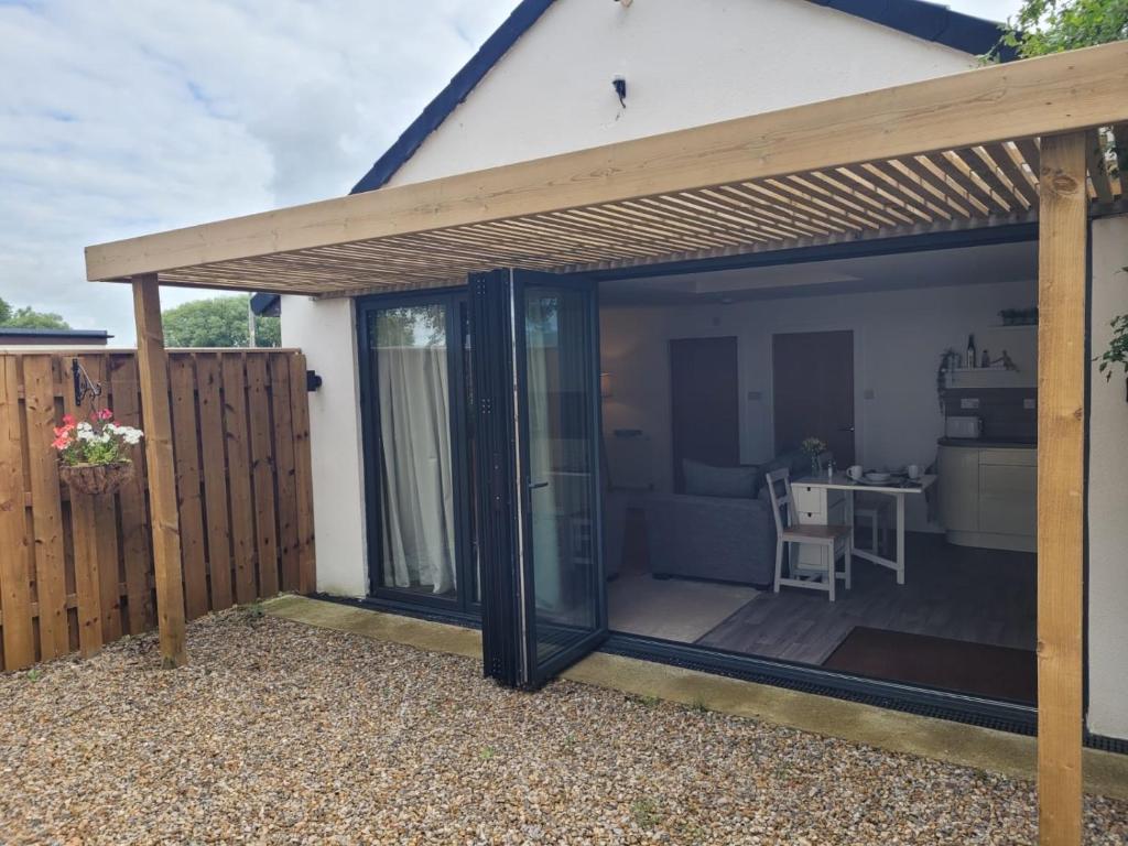 a patio extension with a wooden pergola at Newbus Grange Lodge The Cottage in Darlington