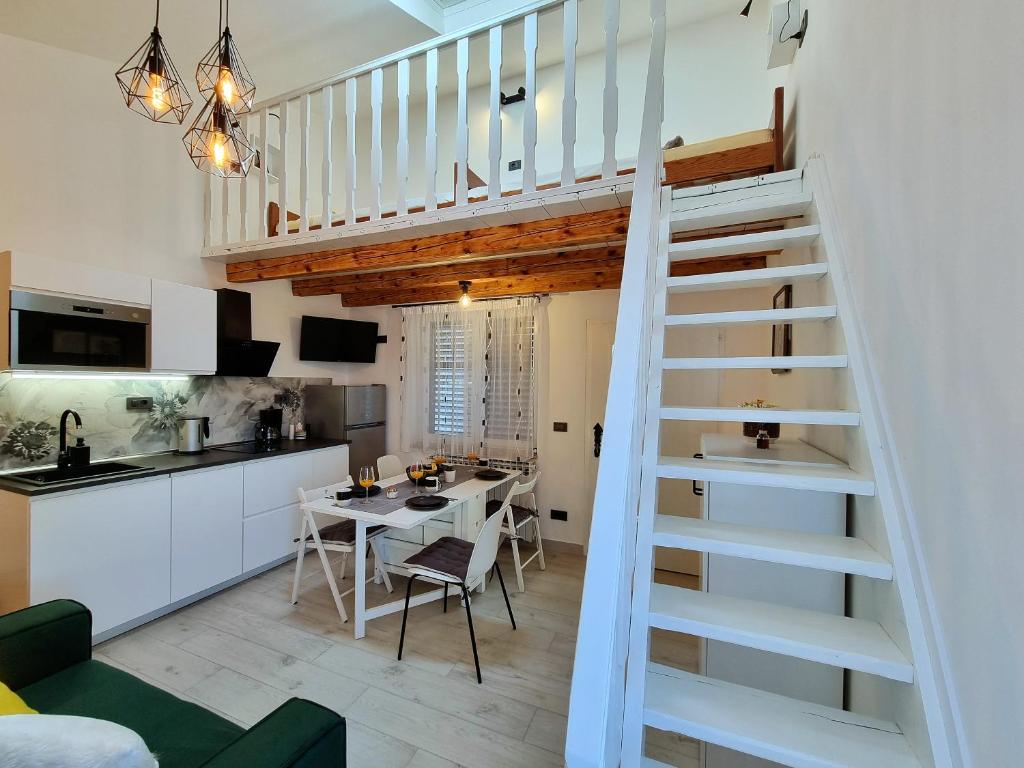 una cucina e un soggiorno con scala a chiocciola di Apartments Zonta 800 m From Beach a Rovigno (Rovinj)