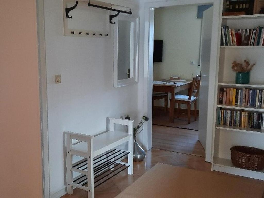 ein Wohnzimmer mit einem weißen Stuhl und einem Bücherregal in der Unterkunft Ferienwohnung Klute in Allendorf