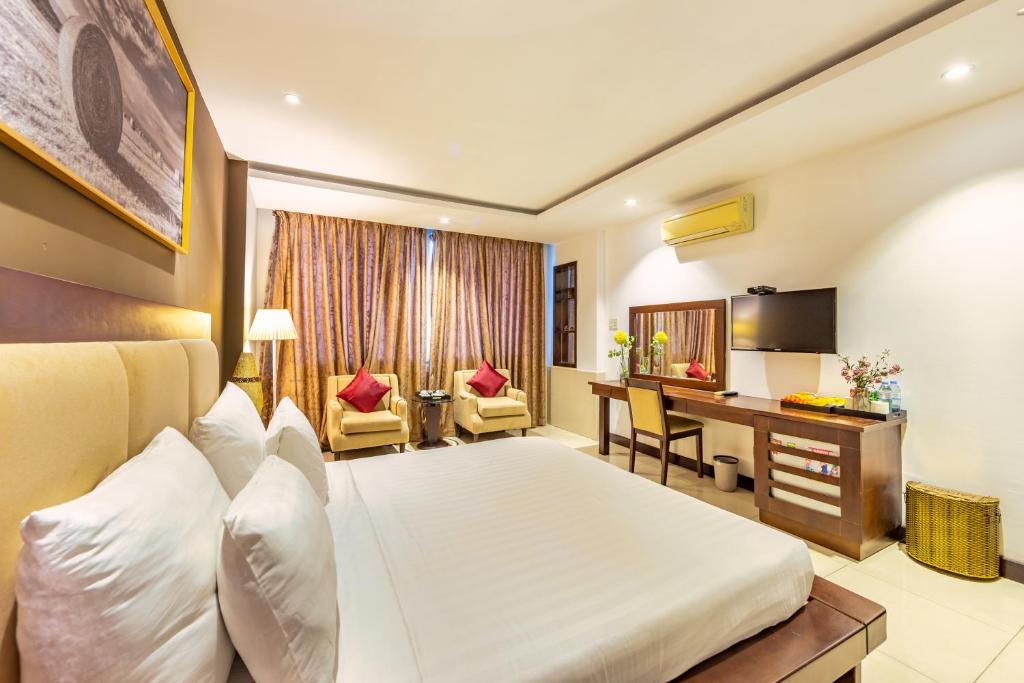 een hotelkamer met een bed en een bureau bij The Noble Swan Central Dong Du Hotel in Ho Chi Minh-stad